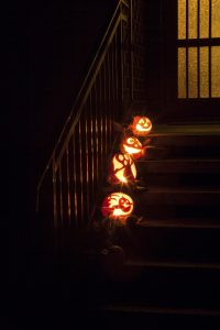 Carved pumpkins line the steps of this spooky front porch.