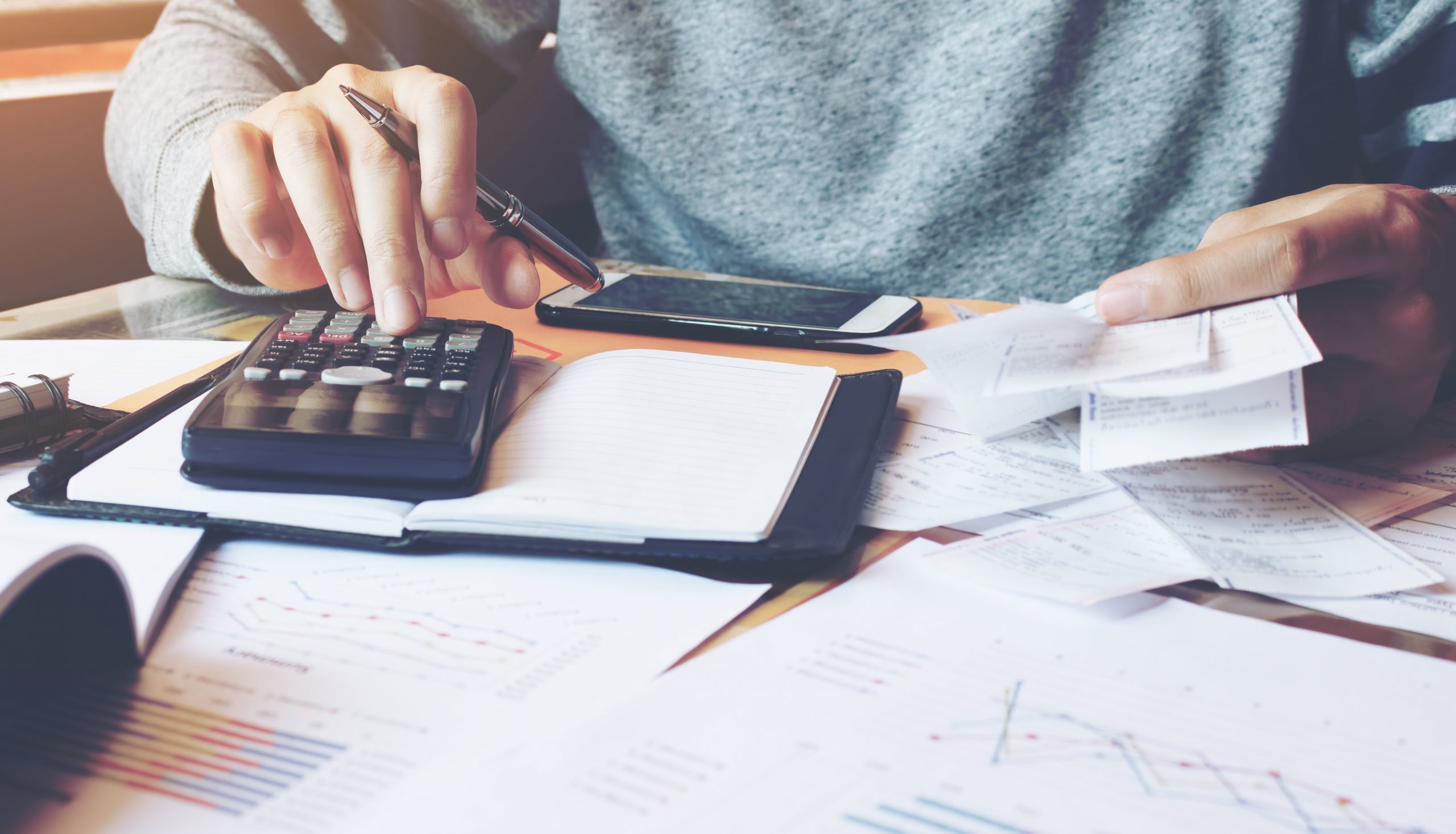 House plans - Person using a calculator to estimate home building costs | Monster House Plans